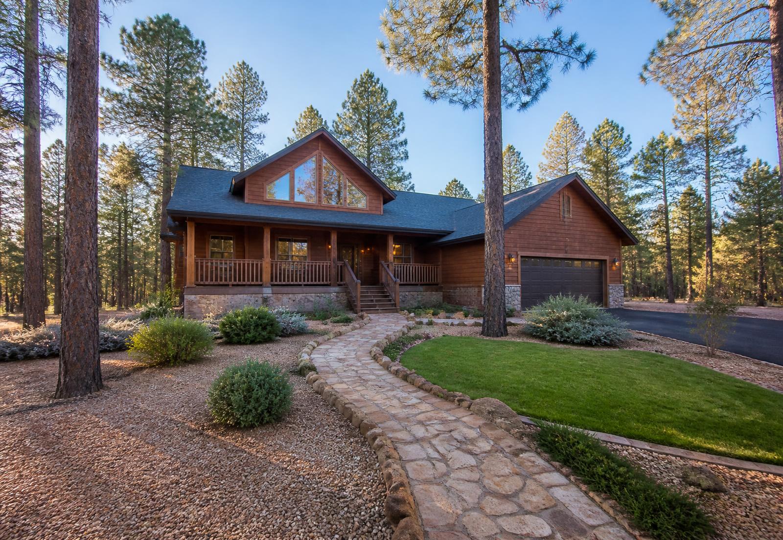 Mountain cabin vacation home surrounded by tall pines with maintained landscaping in Arizona's White Mountains
